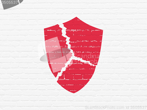 Image of Protection concept: Broken Shield on wall background