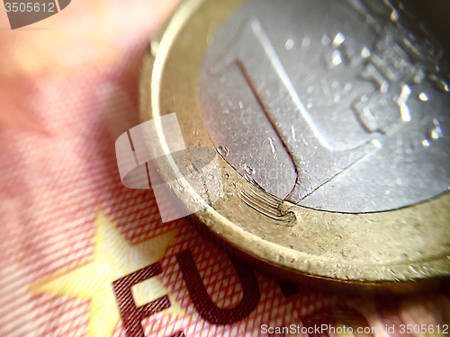 Image of A scratched 1€ coin over a 10€ banknote