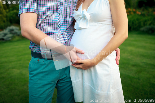 Image of Happy and young pregnant couple in nature