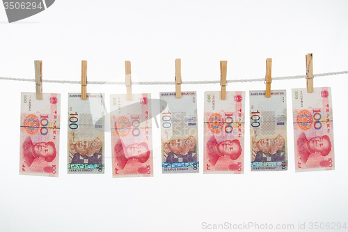 Image of China and Malaysia Currency on Clothesline