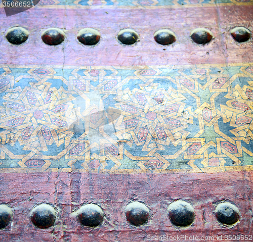 Image of metal nail dirty stripped paint in the brown   red wood door and