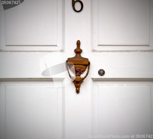 Image of handle in london antique brown door  rusty  brass nail and light