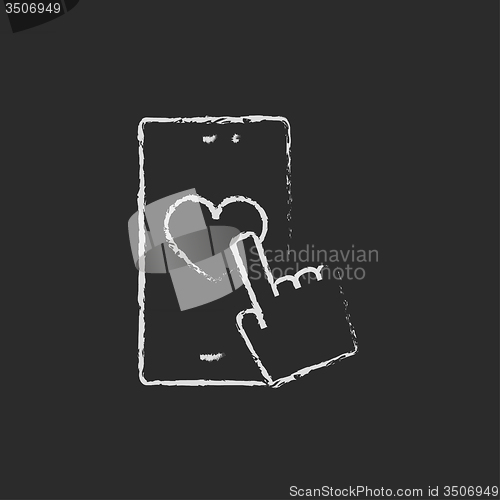 Image of Smartphone with heart sign icon drawn in chalk.