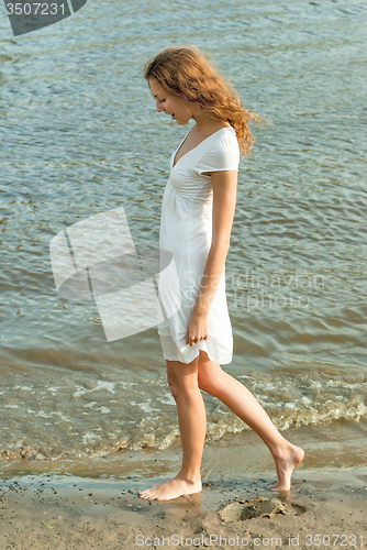 Image of Pretty woman in a white dress on coast