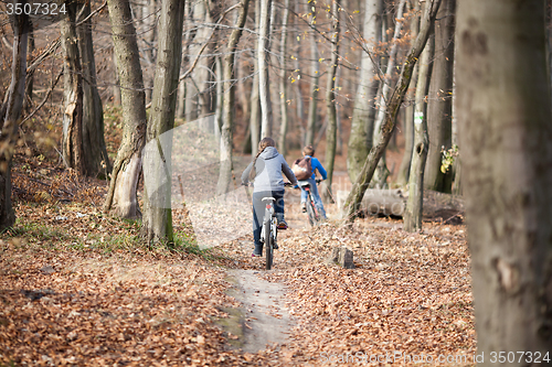 Image of Two children on bicycles in autumn forest