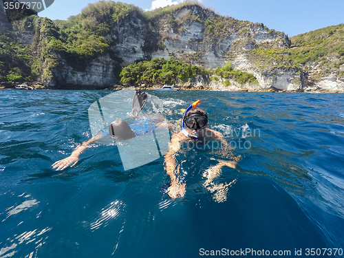 Image of shoot of a young boy snorkeling with father