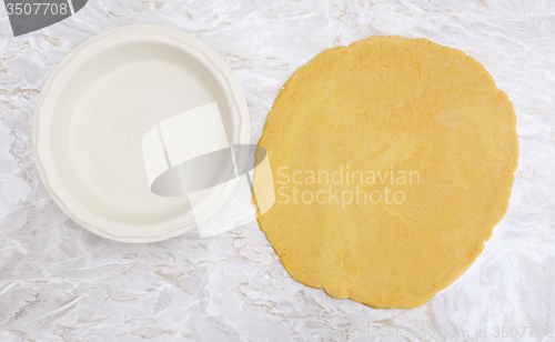 Image of Fresh pastry rolled out in a circle to line pie dish