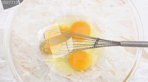 Image of Three eggs with a wire balloon whisk