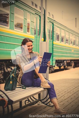 Image of woman takes notes in notepad and laughing