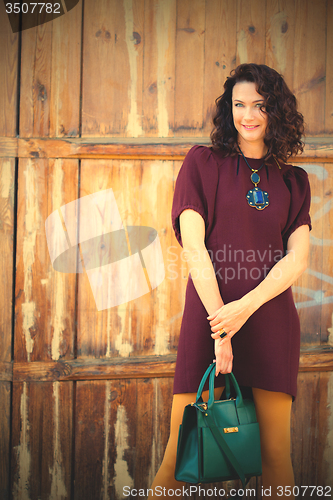 Image of beautiful middle-aged woman in burgundy dress