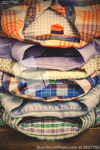 Image of cotton shirts on a wooden shelf in a clothes store