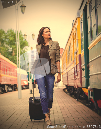 Image of beautiful adult woman with suitcase