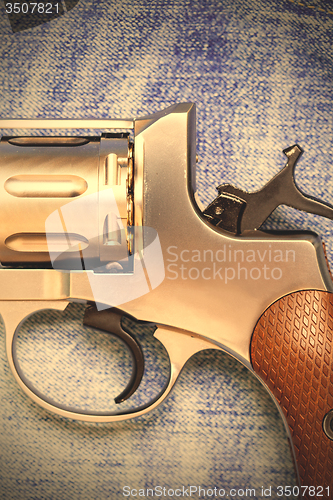 Image of Nagan revolver on blue jeans background