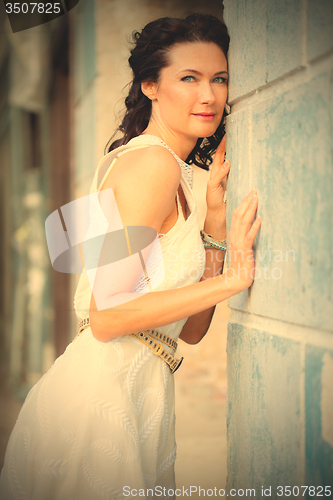 Image of woman in a white dress near the old stone wall