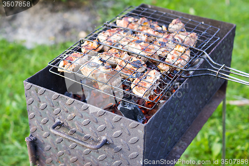 Image of Meat on skewer frying on brazier