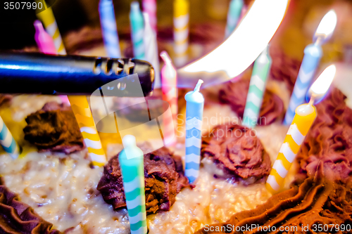 Image of lighting Colorful candles on birthday cake  