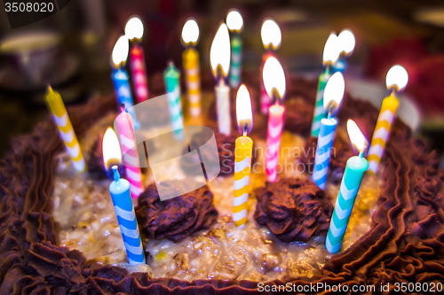 Image of lighting Colorful candles on birthday cake  