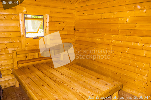 Image of small log cabin interior with bed and window