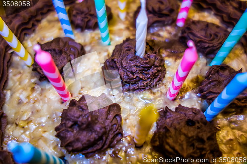 Image of lighting Colorful candles on birthday cake  