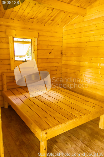 Image of small log cabin interior with bed and window
