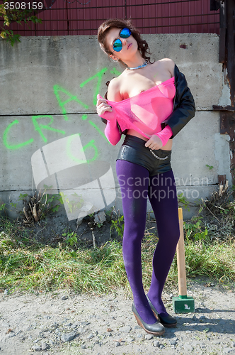 Image of Pretty girl in pink net blouse with sledge hammer