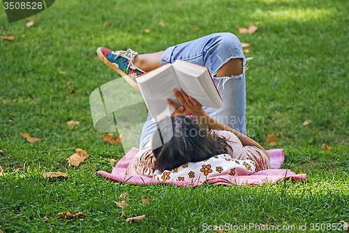 Image of Girl reading a book in the park