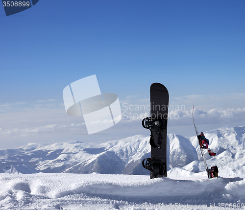 Image of Two snowboards in snow near off-piste slope in sun day