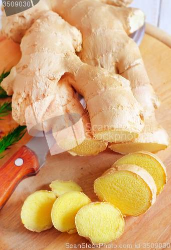Image of Fresh ginger and knife on the wooden board