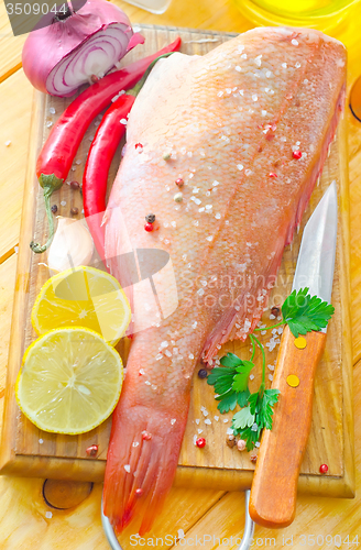 Image of raw fish with aroma spice on wooden background