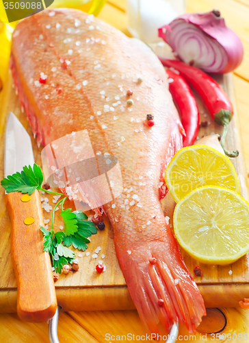 Image of raw fish with aroma spice on wooden background