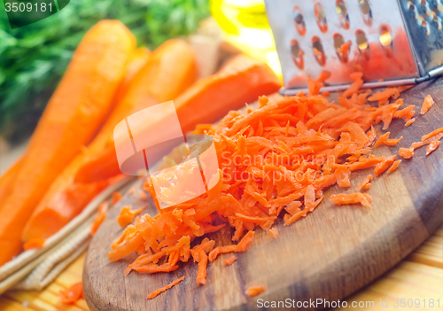 Image of raw carrots and knife on the wooden board