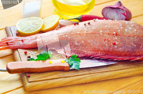 Image of raw fish with aroma spice on wooden background