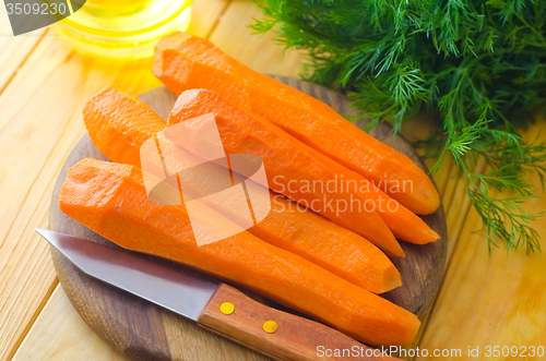 Image of raw carrots and knife on the wooden board