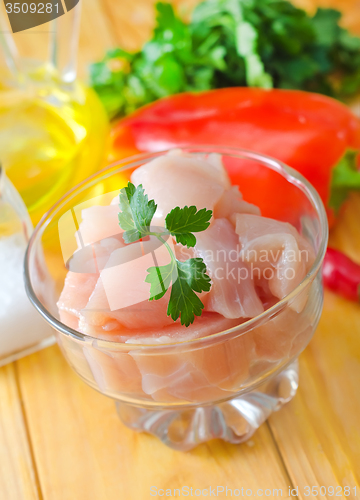 Image of raw chicken and raw vegetables on wooden table