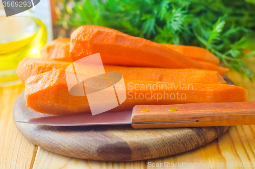 Image of raw carrots and knife on the wooden board