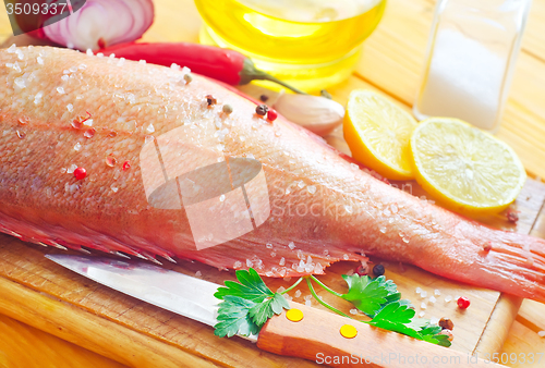 Image of raw fish with aroma spice on wooden background