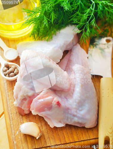 Image of Raw chicken on wooden board, Chicken Wings