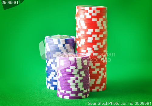 Image of Group from chips for poker on the green background