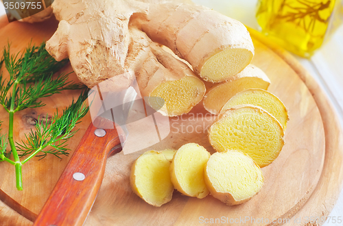 Image of Fresh ginger and knife on the wooden board