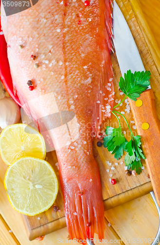 Image of raw fish with aroma spice on wooden background