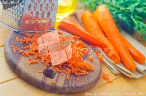 Image of raw carrots and knife on the wooden board