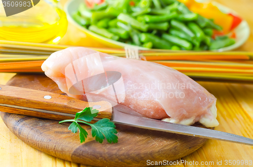 Image of Raw chicken on the wooden board, raw chicken and raw pasta