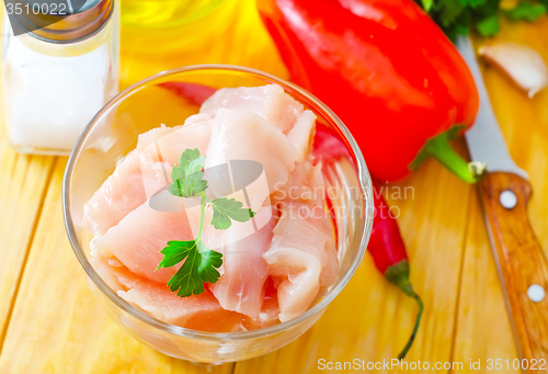 Image of raw chicken and raw vegetables on wooden table