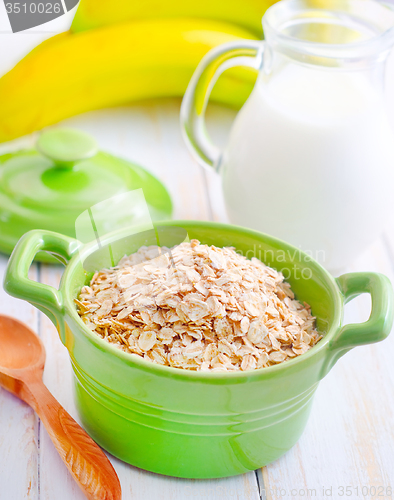 Image of Oat flakes in the green bowl with banana and milk