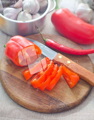 Image of Raw red peppers on the wooden board