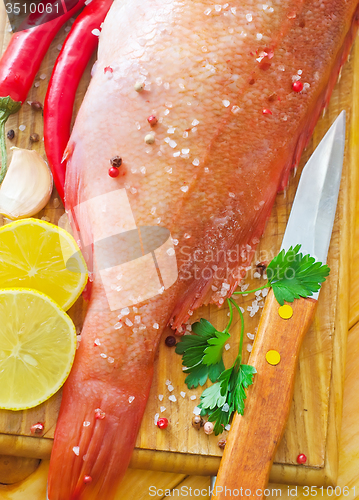 Image of raw fish with aroma spice on wooden background