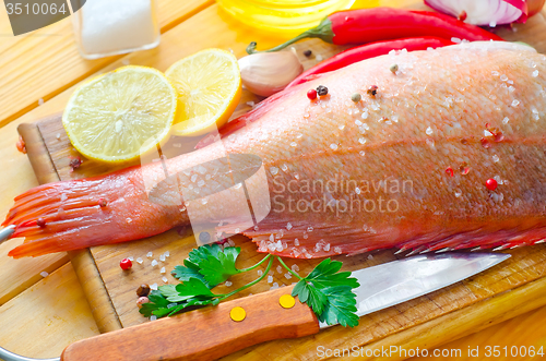 Image of raw fish with aroma spice on wooden background