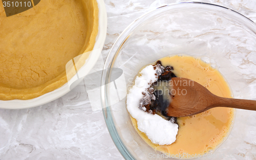 Image of Stirring sugar into beaten egg for pumpkin pie filling