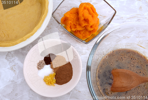 Image of Making pumpkin pie - pastry crust, pumpkin, spices and filling