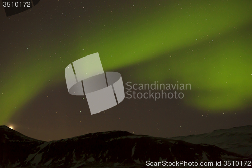 Image of Northern lights with snowy mountains in the foreground